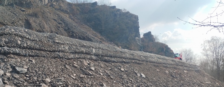 Pohled na skálu a umělý retenční val v přírodní památce Zámky v pražských Bohnicích.